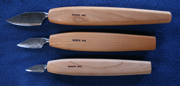 three forged bevel straight knives shown together